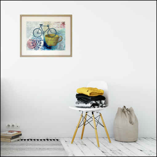 framed giclee print of a bike, a yellow cup and a couple of postal seals on a blue and turquoise painted background, shown on a living room wall